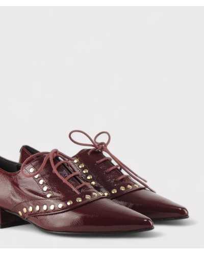 JONI oxford burdeos primer plano tachuelas doradas y textura charol