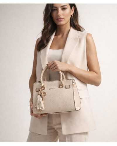 Model carrying Liu Jo beige satchel bag with braided handles and tassel pendant