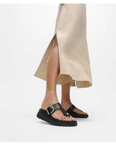 Sandalias FitFlop Gen-FF Buckle negras puestas con falda satén beige