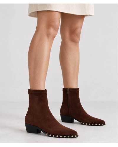Modelo con botines Noa Harmon Lil Kansas marrones y falda corta color crudo