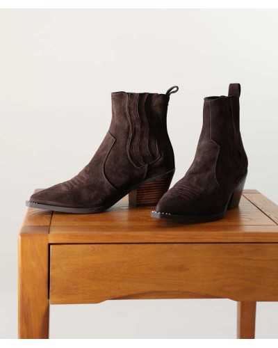 Par de botines Noa Harmon Wind de ante marrón sobre una mesa de madera