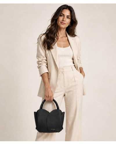 Mujer con traje beige llevando el bolso Roselle negro de Noa Harmon