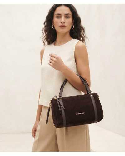 Bolso bowling Hispanitas chocolate colgado del hombro, combinado con pantalón ancho beige y top crudo