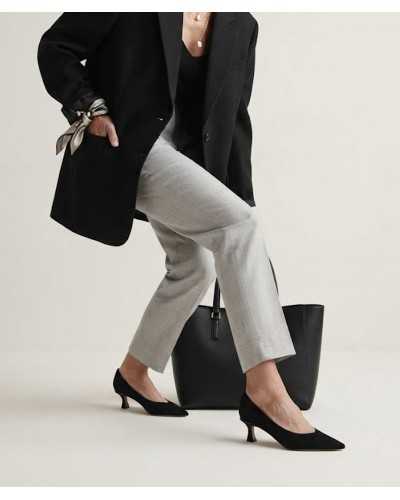 Mujer con pantalón de traje gris, americana negra y salones de ante negro Alma en Pena