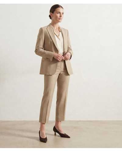 Mujer con traje beige y blusa crema y salones de ante marrón chocolate Alma en Pena