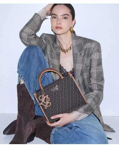 Mujer sentada con americana de cuadros, vaqueros y botas camperas, con el tote Liu Jo de monograma