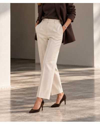 Mujer con salones de ante chocolate, pantalón crudo de pinzas, jersey y americana marrones