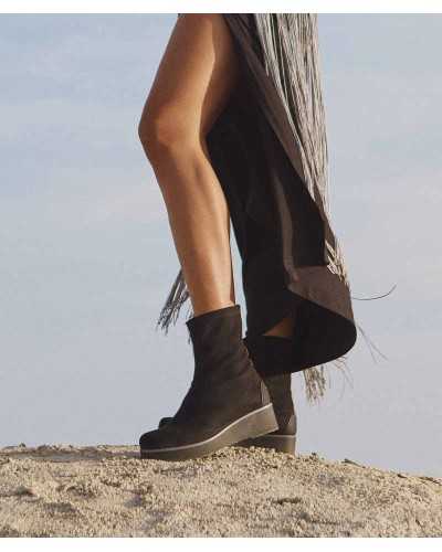 Piernas con botines calcetín Burano negros de cuña de goma y vestido largo negro con flecos plateados