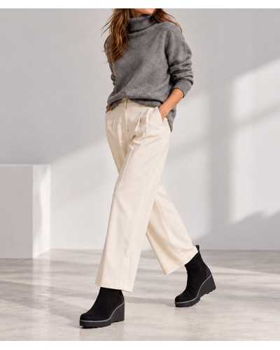 Mujer con botines de cuña negros, pantalón ancho crudo de pinzas y jersey gris de cuello alto