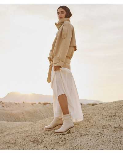 Botín Temuco blanco roto con falda midi blanca y gabardina beige