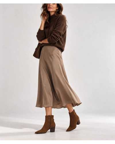 Mujer con botines cowboy Dibia color cuero, falda midi topo y jersey de punto marrón