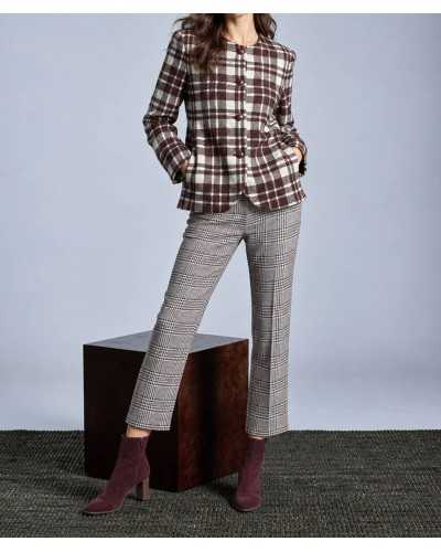 Mujer con boina crudo, chaqueta de cuadros marrón y crudo, pantalón tobillero de príncipe de Gales y botines de serraje burdeos