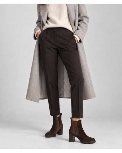 Botín chelsea Joni de serraje marrón chocolate puesto en modelo, look con abrigo gris y pantalón de pinza marrón