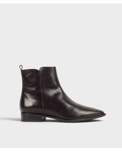Botín plano de piel marrón chocolate con brillo suave y punta afilada, vista lateral