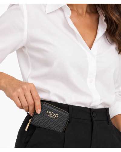 Cartera zip around Liu Jo negra con monograma en la mano de una modelo