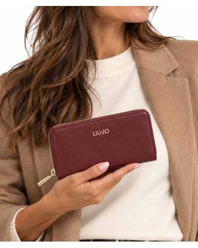 Cartera grande Liu Jo burdeos en la mano de una modelo