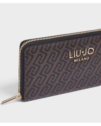 Detalle del logo dorado, el grano fino del monograma y la cremallera de la cartera Liu Jo