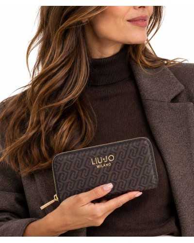 Cartera grande Liu Jo marrón con monograma en la mano de una modelo