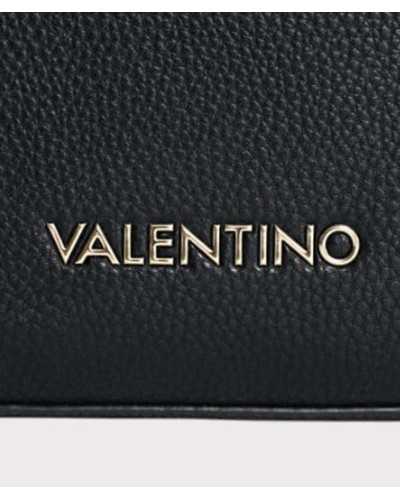 Detalle del logo VALENTINO dorado sobre piel sintética negra granulada