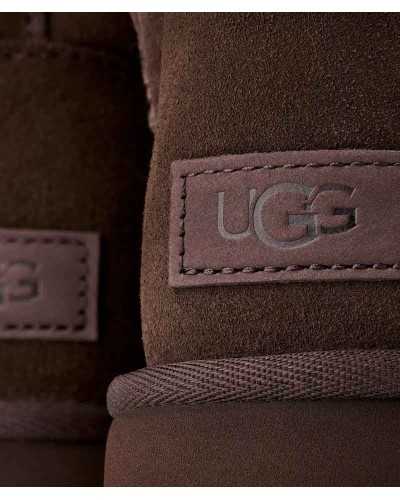 Detalle del parche con el logo de UGG grabado en marrón sobre la piel de oveja chocolate